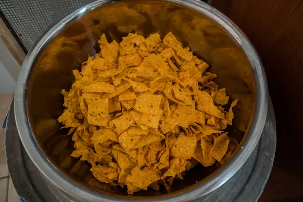 Tortilla chips served in a bamboo basket with a flat lay concept, the tortilla chips are fried golden yellow and very crunchy
