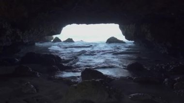 Stunning beach at the end of the mouth of the cave with white sand, coral and big waves, the beauty is extraordinary and enchanting