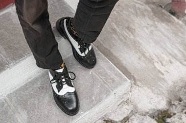 Genç adam klasik bir iki tonluk hakiki deri ayakkabı giydi. Parlak ve güneşli bir günde takılmaya hazır eski moda ayakkabılar..