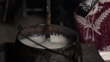 Hindistan cevizi kabuklarından elde edilen medya kullanarak sıvı palmiye şekerini şekillendirme işlemi. Endonezya 'daki köylülerin katı palmiye şekeri üretme sürecinin ayrıntıları