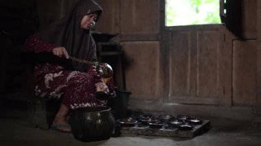 Hindistan cevizi kabuklarından elde edilen medya kullanarak sıvı palmiye şekerini şekillendirme işlemi. Endonezya 'daki köylülerin katı palmiye şekeri üretme sürecinin ayrıntıları