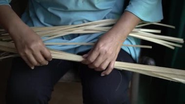 Bambudan küçük torbalar yapan bambu ustalarının ellerinin ayrıntıları. Elle bambu torbası üreten bambu zanaatkarlarının görüntüleri.