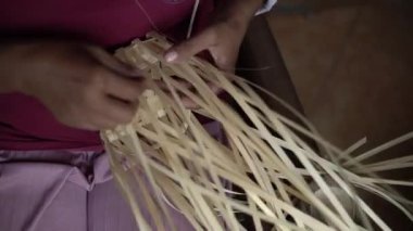 Bambudan küçük torbalar yapan bambu ustalarının ellerinin ayrıntıları. Elle bambu torbası üreten bambu zanaatkarlarının görüntüleri.
