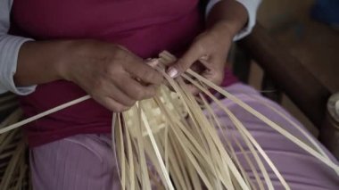 Bambudan küçük torbalar yapan bambu ustalarının ellerinin ayrıntıları. Elle bambu torbası üreten bambu zanaatkarlarının görüntüleri.
