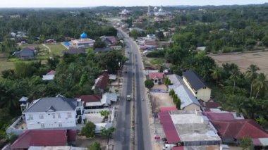 Yakın evleri ve yolları olan yoğun nüfuslu bir bölgenin yavaş çekim görüntüleri. Doğu Aceh, Endonezya 'da hareketli bir kıyı bölgesinin panoramik yavaş çekim drone görüntüleri