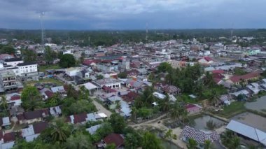 Yakın evleri ve yolları olan yoğun nüfuslu bir bölgenin yavaş çekim görüntüleri. Doğu Aceh, Endonezya 'da hareketli bir kıyı bölgesinin panoramik yavaş çekim drone görüntüleri