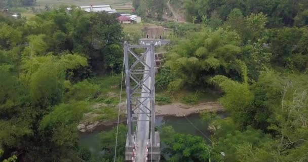 Imágenes Aéreas Puente Colgante Que Divide Río Con Exuberantes Árboles — Vídeo de stock