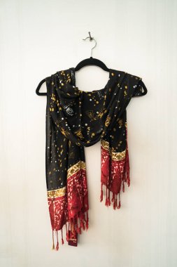 Geleneksel Java batik motif eşarpları beyaz bir duvara asılır. Batik motifli bu eşarp çeşitli motif ve renklere sahip profesyonel zanaatkarlar tarafından elle çizilmiştir.