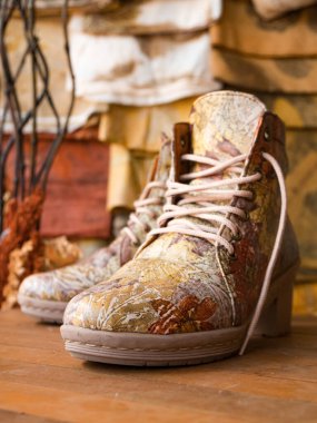 Deri çizmelerle doğal malzemelerden ekoprint işçiliği yapıyor. Ekoprint tekniği, ayakkabı yüzeyindeki motif ve renklerin görünümünde soyut tasarımlar yaratmak için istiflenmiş yaprakları kullanır.