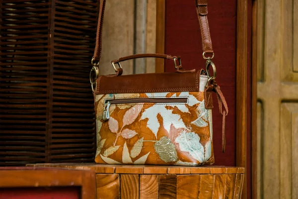 Display of leather bags for women made by craftsmen in Indonesia. Various types of detailed and beautiful women\'s bags are combined with eco print artwork with leaf and flower motifs