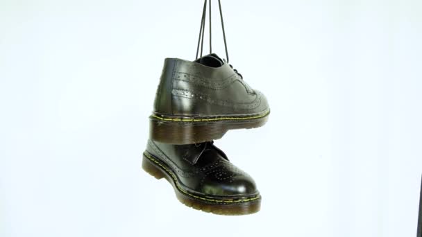 全黑的翼尖罗布鞋 鞋底用橡胶 鞋带挂在白色的背景上 本地工匠手工制作的高档经典翼尖鞋的细节 — 图库视频影像
