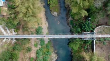 Sadece iki tekerlekli araçlar tarafından kullanılabilen ve sırayla geçilebilen asma köprünün hava görüntüleri. Motorsikletler nehirleri ve vadileri ayıran asma köprüleri geçiyor