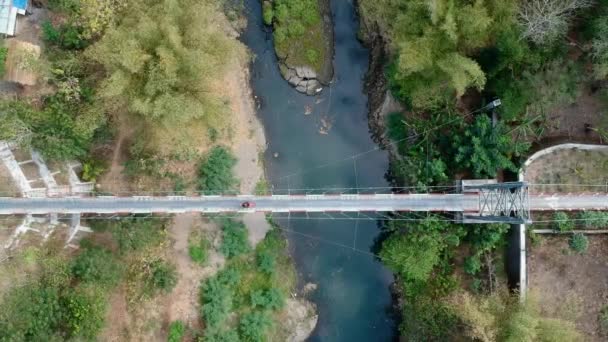 2輪車のみで使用できる吊り橋の空中映像を交互に交差させることができる オートバイクロスサスペンションブリッジ 川とラヴィンを分割 — ストック動画