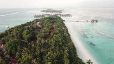 Tropik hava manzarası, deniz manzarası su bungalovu villaları, yemyeşil ağaçlar, çarpıcı beyaz kumsallar. Maldivler egzotik bir turizm merkezi. Tropikal atmosferi olan bir turizm cenneti..