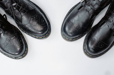 Klasik bir kanat ucu modeli ve parlak siyah bir Mary Jane mankeni olan iki çift erkek ve kadın ayakkabısı konsepti. Temiz beyaz arka planda el yapımı bir çift eski ayakkabının fotoğrafı.