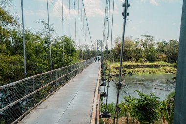 Sadece iki tekerlekli araçlar tarafından kullanılabilen ve sadece sırayla geçebilen bir asma köprü. Kırsal bölgelerdeki nehirleri bölen asma köprülerin toplum üzerinde çok olumlu bir etkisi vardır.