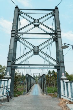 Sadece iki tekerlekli araçlar tarafından kullanılabilen ve sadece sırayla geçebilen bir asma köprü. Kırsal bölgelerdeki nehirleri bölen asma köprülerin toplum üzerinde çok olumlu bir etkisi vardır.