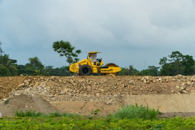 İki şehri birbirine bağlayan bir paralı yolun inşaatı için mekan. Gündüz boyunca proje alanından geçen kazıcılar, sıkıştırıcılar ve dozerler var