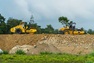 İki şehri birbirine bağlayan bir paralı yolun inşaatı için mekan. Gündüz boyunca proje alanından geçen kazıcılar, sıkıştırıcılar ve dozerler var