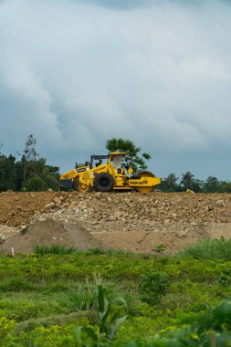 İki şehri birbirine bağlayan bir paralı yolun inşaatı için mekan. Gündüz boyunca proje alanından geçen kazıcılar, sıkıştırıcılar ve dozerler var