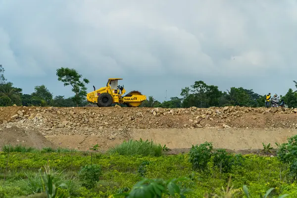 The location for the construction of a toll road connecting the two cities. There are excavators, compactors & dozers busy passing through the project area during the day