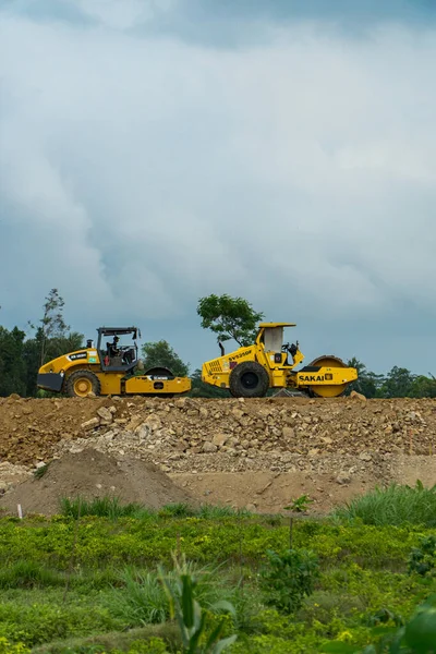 The location for the construction of a toll road connecting the two cities. There are excavators, compactors & dozers busy passing through the project area during the day