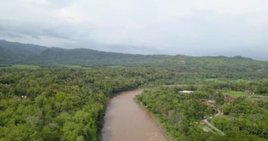 Endonezya 'nın Yogyakarta kentindeki Progo Nehri' nin hava görüntüleri. Çok büyük, kahverengi renkli ve bol kayalıklı. Yüksek uçurumlar ve sık ağaçlarla çevrili bir nehrin insansız hava aracı videosu