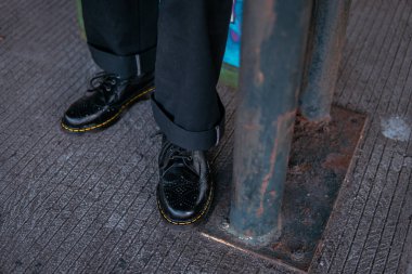Terk edilmiş bir depoda erkek bir mankenin giydiği hakiki deriden yapılmış siyah kanat uçlu ayakkabıların yakın görüntüsü. Demirden yapılmış eski bir binada klasik kanat ucu ayakkabı konsepti.