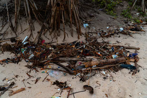 Plastic waste scattered and hit by sea waves. Marine pollution is caused by the use of single-use plastics that are thrown away carelessly, thereby damaging the environment, ecology and water.