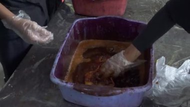 Geleneksel batik kumaşı boyamayı öğrenen öğrencilerin havuza boya bandırıp kaynar suya batırdıkları 4K 'lık görüntüleri kapatın. Yeni başlayanlar batik kumaşı geleneksel şekilde boyamayı öğrenirler.