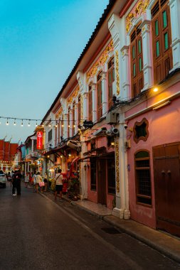 Günbatımının altın ışığı Phuket, Tayland 'daki yüz yıllık Çin-Portekiz kasaba evlerini aydınlatıyor. Eski şehirde güneş turistlerle dolu.