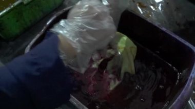 Katılımcıların geleneksel batik kumaşı boyamayı öğrenirken havuza boya bandırıp kaynar suya batırdıkları yavaş çekim görüntüleri. Yeni başlayanlar batik kumaşı geleneksel şekilde boyamayı öğrenirler.