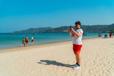 Phuket, Tayland 'ın en sevilen plajlarından biri olan Patong Sahili, suda oynamak, güneşlenmek veya tropikal iklimin tadını çıkarmak için pek çok turist tarafından ziyaret ediliyor.