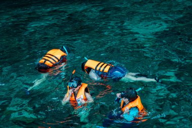 Uçsuz bucaksız denizin güzelliği ve bir Google ve can yeleği kullanarak şnorkelle yüzerek sudaki biyotayı görmek. Phi-phi Adası 'nda şnorkelle yüzmek, Mueang Krabi, Tayland büyüleyici kayalık manzaralı