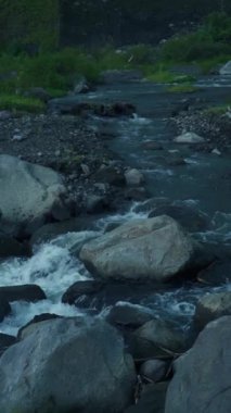 Bir nehir kayaların arasından akar ve akıntılar yaratır. Nehrin yukarısında etrafındaki kayalar hala güzel ve doğal.