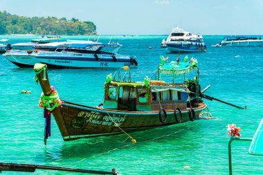 Geleneksel Tayland tekneleri rıhtıma yanaşır ve Tayland 'daki Phi-phi Adası' nı gezer. Geleneksel ahşap ve süslü tekneler turistler için tercih edilen taşımacılıktır