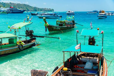 Geleneksel Tayland tekneleri rıhtıma yanaşır ve Tayland 'daki Phi-phi Adası' nı gezer. Geleneksel ahşap ve süslü tekneler turistler için tercih edilen taşımacılıktır