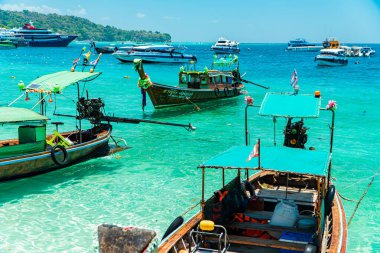 Geleneksel Tayland tekneleri rıhtıma yanaşır ve Tayland 'daki Phi-phi Adası' nı gezer. Geleneksel ahşap ve süslü tekneler turistler için tercih edilen taşımacılıktır