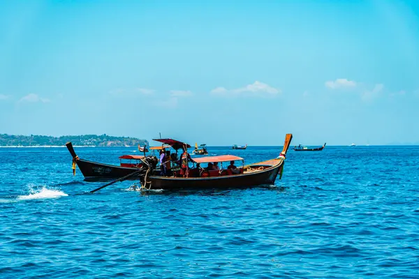 Geleneksel Tayland tekneleri rıhtıma yanaşır ve Tayland 'daki Phi-phi Adası' nı gezer. Geleneksel ahşap ve süslü tekneler turistler için tercih edilen taşımacılıktır