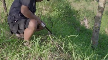 Bir adamın tepenin üzerine çarşaf dikme süreci. Ormanın ortasında, Merapi Dağı 'nın çarpıcı zemininde tek başına kalan bir adam çiselemeden korunmak için bir çarşaf dikiyor..