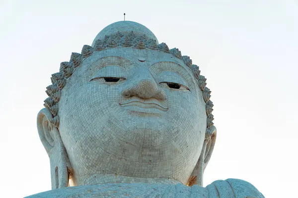The Big Buddha statue is one of the revered landmarks in Phuket, Thailand. Close-up of the Big Buddha statue made of concrete covered with white Burmese marble depicting Gautama in a sitting position