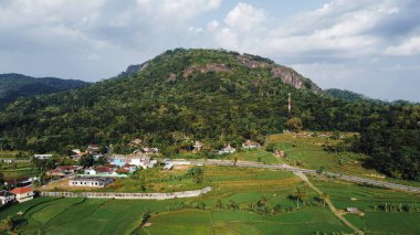 Öğleden sonra Nglanggeran Eski Volkan eko eko alanının panoramik görüntüsü. Pirinç tarlaları ve köylerle çevrili antik bir kaya tepesinin hava görüntüleri..