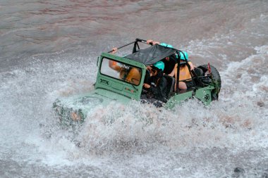 Jeep turları, nehirleri yüksek hızda geçerek aşırı ve zorlu rotalar izler. Böylece hava her yöne sıçrar ve yolcuları ıslatır. O anda su sıçradı ve cip ve yolcular ıslandı.
