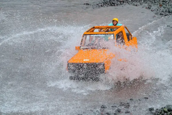 stock image Jeep tours take extreme and challenging routes by crossing rivers at high speed so that the air splashes in all directions and wets the passengers. At that time water splashes soared and wet the jeep and passengers