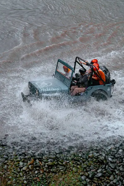 stock image Jeep tours take extreme and challenging routes by crossing rivers at high speed so that the air splashes in all directions and wets the passengers. At that time water splashes soared and wet the jeep and passengers