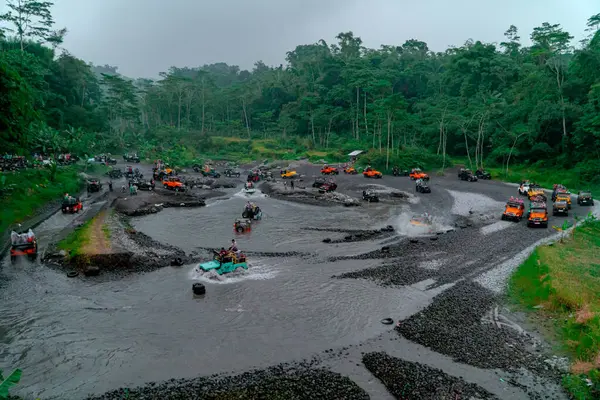 stock image The jeep tour takes an extreme and challenging route by crossing a river at high speed so that the air splashes in all directions and wets the passengers.