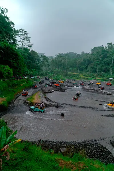 stock image The jeep tour takes an extreme and challenging route by crossing a river at high speed so that the air splashes in all directions and wets the passengers.