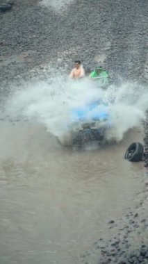 Su her yöne sıçrayıp Merapi Dağı eteğindeki lav turunda yolcuları ıslatana kadar yüksek hızda nehirden geçen bir off-road turist cipinin yavaş çekim görüntüleri.