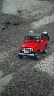 Su her yöne sıçrayıp Merapi Dağı eteğindeki lav turunda yolcuları ıslatana kadar yüksek hızda nehirden geçen bir off-road turist cipinin yavaş çekim görüntüleri.