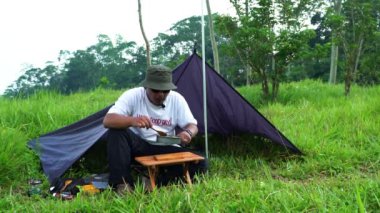 Bushcraft Kavramı ormanda tereyağı soslu tavuk pişiriyor. Sakin ve rahat bir atmosferde en az teçhizatla doğadaki yemek pişirme faaliyetlerini kapatın.